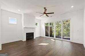 unfurnished living room with a healthy amount of sunlight, dark hardwood / wood-style flooring, and ceiling fan