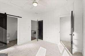 unfurnished bedroom featuring a barn door