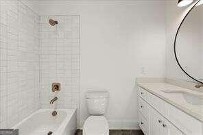 full bathroom featuring toilet, vanity, and tiled shower / bath