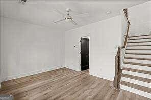 unfurnished living room with ceiling fan and wood-type flooring