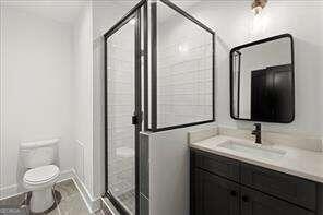 bathroom featuring vanity, toilet, and walk in shower