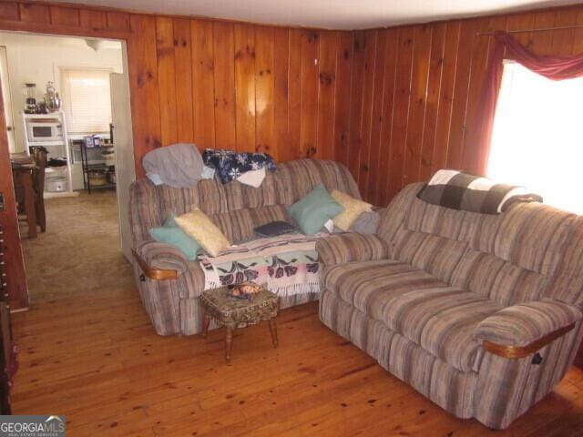 living area featuring wood walls and light wood-type flooring