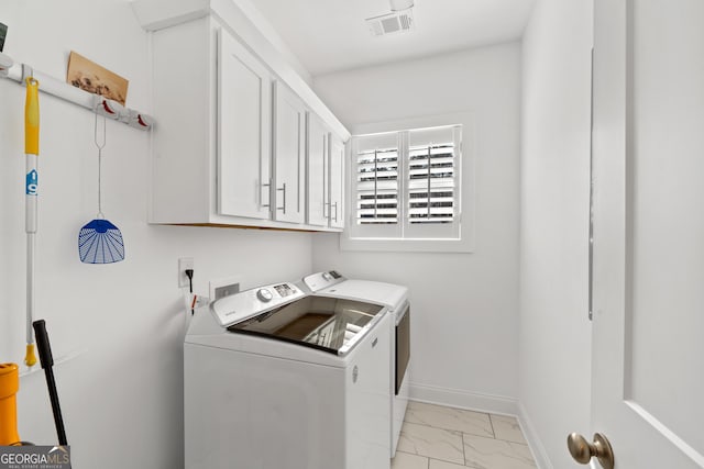 washroom featuring cabinets and separate washer and dryer