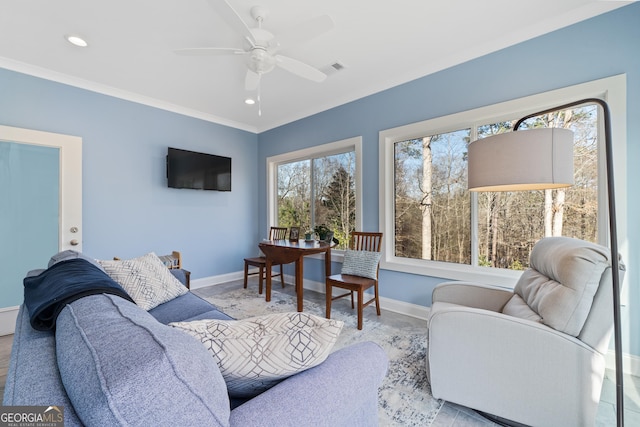 living room with ornamental molding and ceiling fan