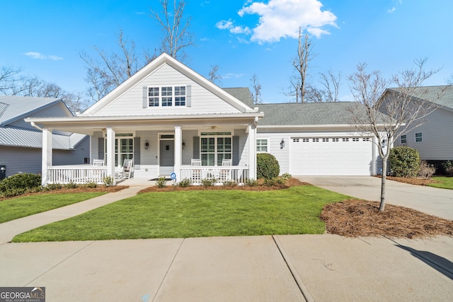 view of front of property featuring a front lawn, a porch, and a garage