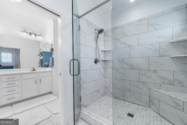 bathroom featuring a shower with shower door and vanity