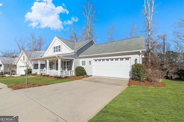 view of front of home with covered porch, a front lawn, and a garage