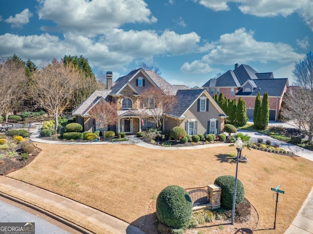 traditional-style home with a chimney and a front lawn