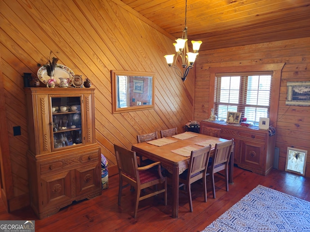 dining room with wood walls, dark hardwood / wood-style floors, an inviting chandelier, and wood ceiling