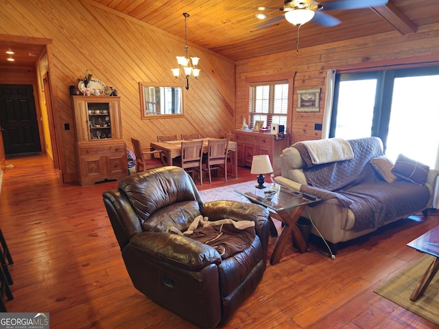 living room with dark wood-type flooring, wooden ceiling, and ceiling fan with notable chandelier