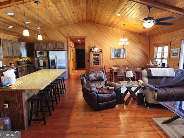 living room with wood walls, lofted ceiling, dark hardwood / wood-style floors, and wood ceiling