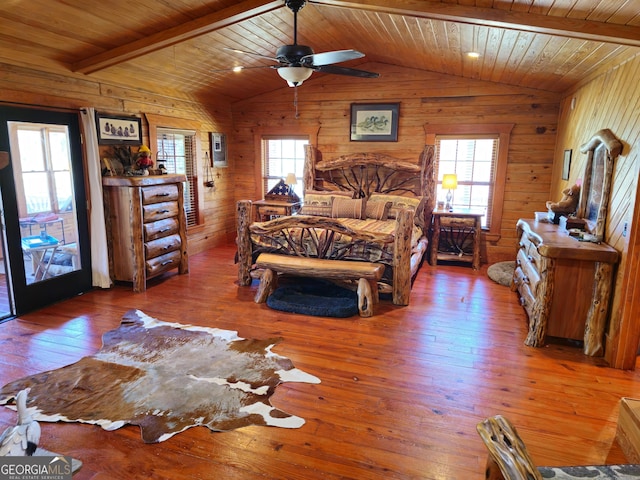 bedroom with wood-type flooring, wood walls, vaulted ceiling with beams, and wood ceiling