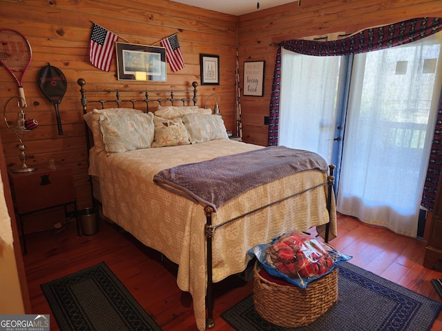 bedroom with hardwood / wood-style floors and wood walls