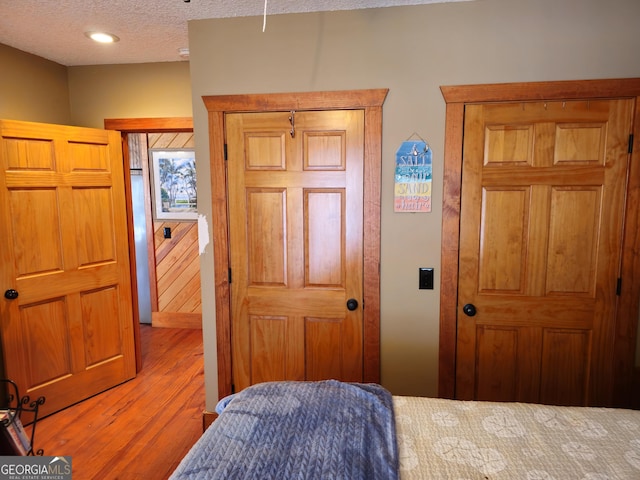 bedroom with light wood-type flooring and a textured ceiling