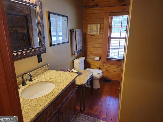 bathroom with toilet, vanity, and wood-type flooring