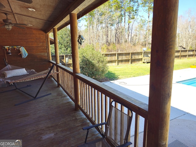 wooden deck featuring a lawn and ceiling fan