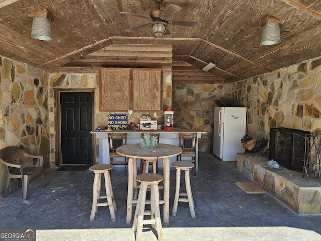 kitchen featuring a fireplace, lofted ceiling, white fridge, and ceiling fan