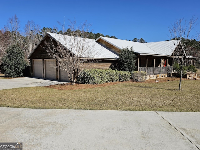 view of front of property with a garage, a front lawn, and a porch