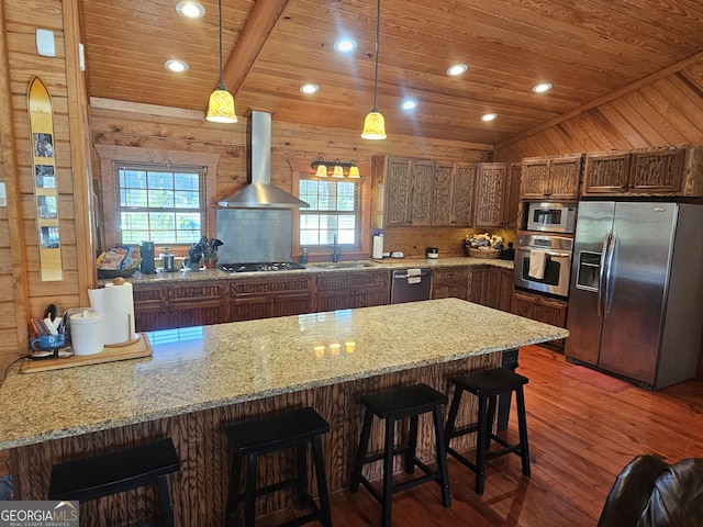 kitchen featuring appliances with stainless steel finishes, sink, lofted ceiling, pendant lighting, and wall chimney exhaust hood