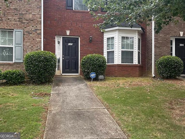 entrance to property with a lawn