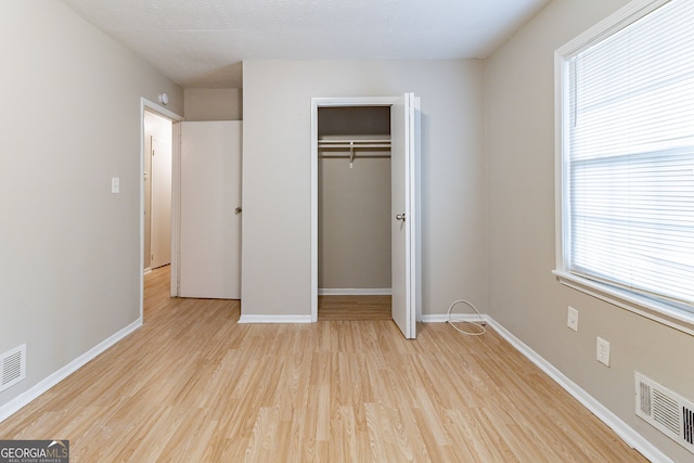 unfurnished bedroom with a closet and light hardwood / wood-style flooring