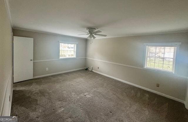 unfurnished bedroom with ornamental molding, dark colored carpet, baseboards, and a ceiling fan