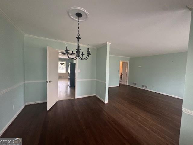 unfurnished dining area with dark wood-style floors, ornamental molding, visible vents, and baseboards