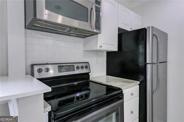 kitchen with white cabinets, stainless steel appliances, and decorative backsplash