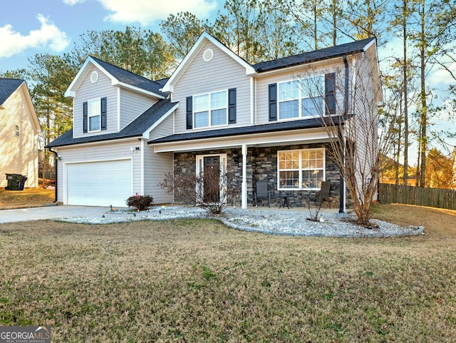 view of front property featuring covered porch, a front yard, and a garage