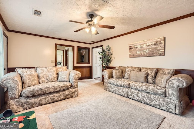 carpeted living room featuring ceiling fan, a textured ceiling, and ornamental molding