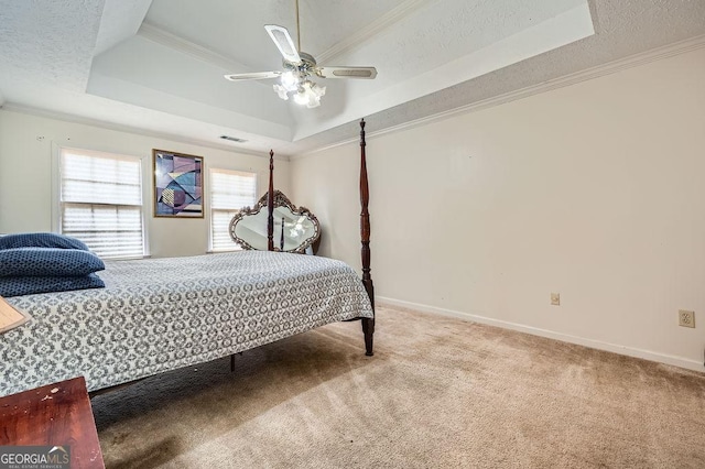 bedroom featuring carpet flooring, crown molding, a raised ceiling, and a textured ceiling