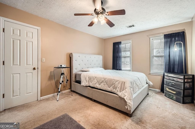 carpeted bedroom with a textured ceiling and ceiling fan