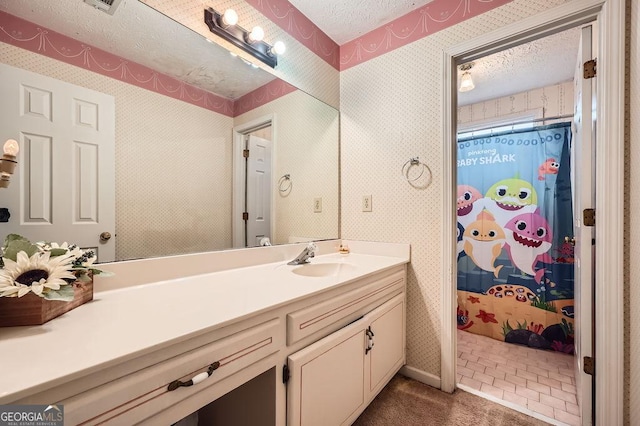 bathroom with a textured ceiling, vanity, and tile patterned floors