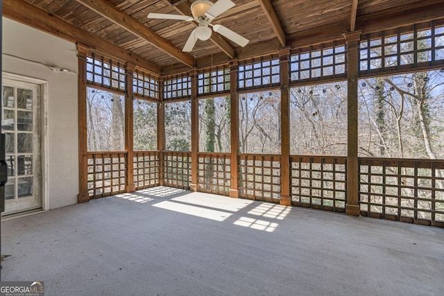 unfurnished sunroom featuring wood ceiling, beamed ceiling, and ceiling fan