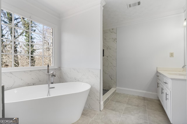 bathroom featuring a freestanding tub, vanity, visible vents, and ornamental molding