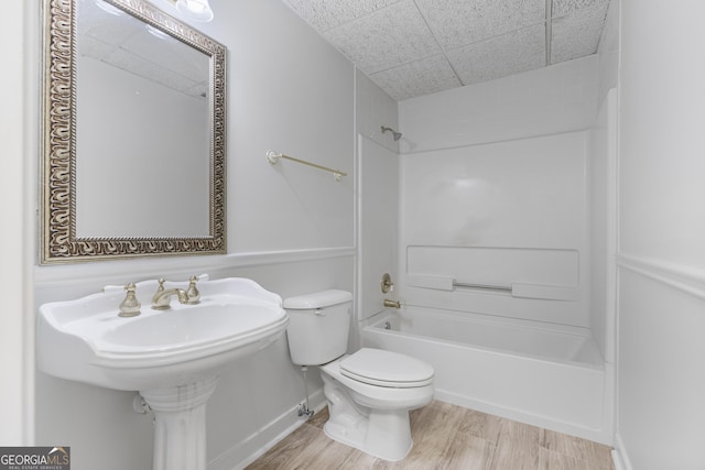 bathroom featuring toilet, wood finished floors, and shower / bathtub combination