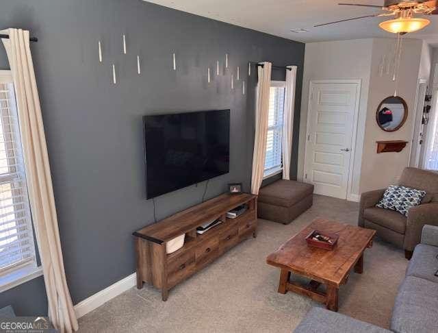 living room featuring ceiling fan and light colored carpet