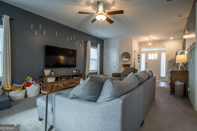 carpeted living room featuring ceiling fan and a healthy amount of sunlight