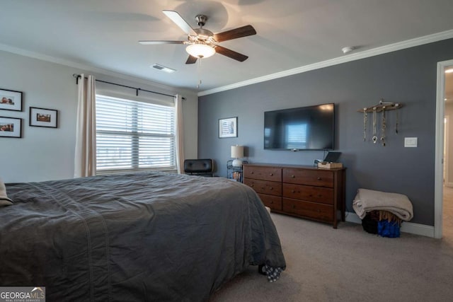 carpeted bedroom with ceiling fan and ornamental molding