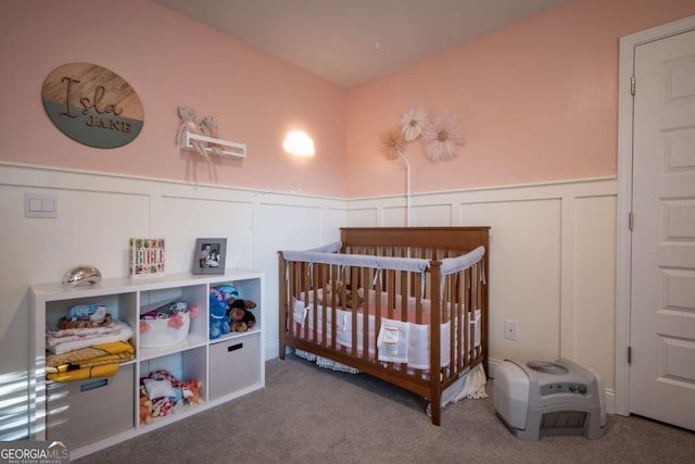 carpeted bedroom featuring a nursery area