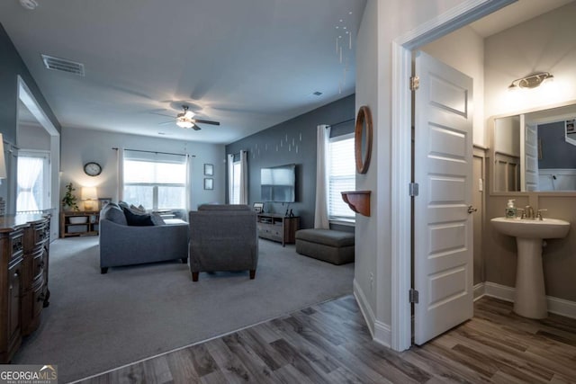 living room featuring ceiling fan, hardwood / wood-style floors, and a healthy amount of sunlight