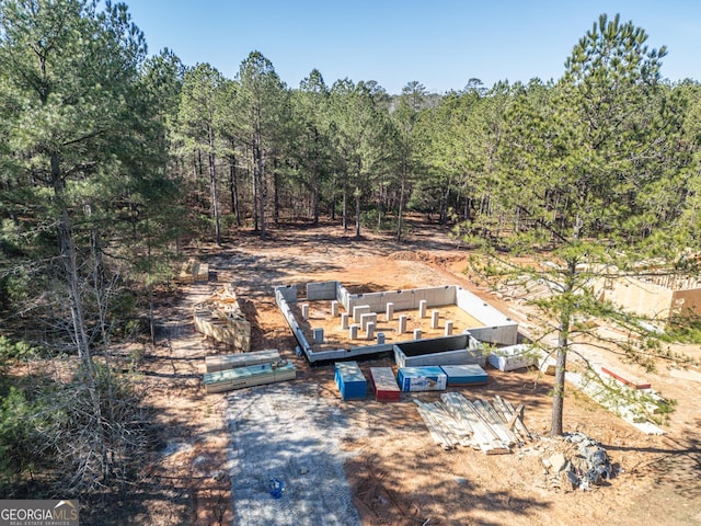 birds eye view of property featuring a wooded view