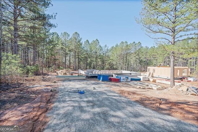 view of parking featuring a view of trees