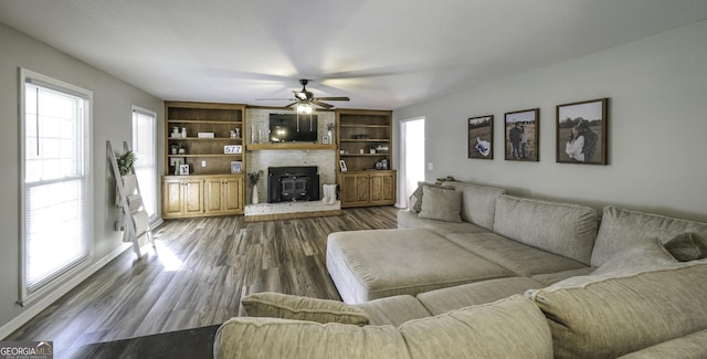 living room featuring ceiling fan and dark wood-type flooring