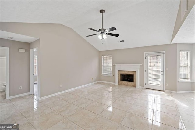 unfurnished living room with ceiling fan, light tile patterned flooring, a brick fireplace, and lofted ceiling