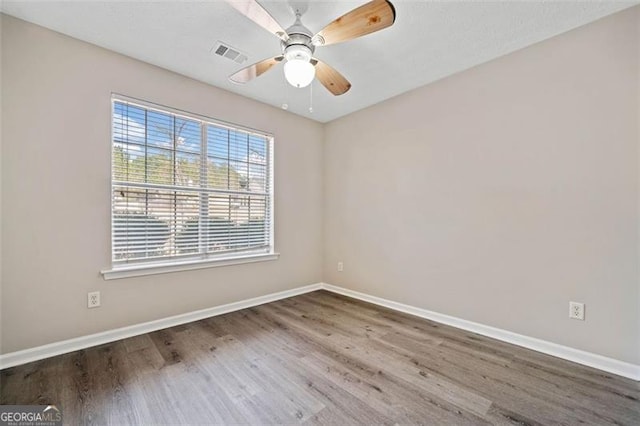 unfurnished room with ceiling fan and hardwood / wood-style floors