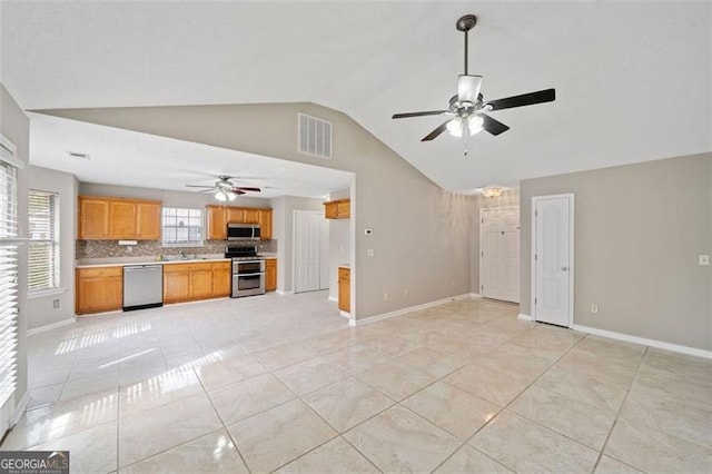 kitchen featuring appliances with stainless steel finishes, ceiling fan, light tile patterned floors, and tasteful backsplash