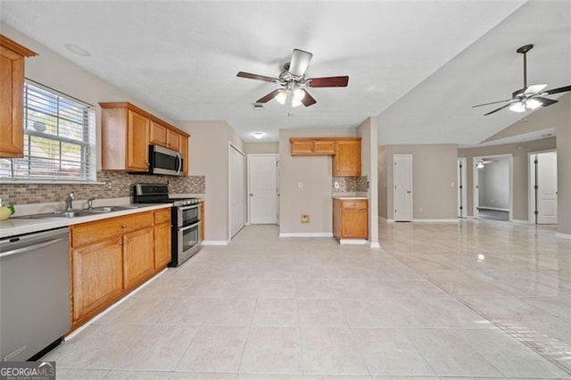 kitchen with appliances with stainless steel finishes, ceiling fan, light tile patterned flooring, decorative backsplash, and sink