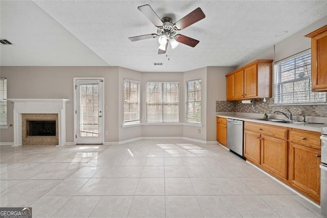 kitchen featuring light tile patterned floors, sink, backsplash, ceiling fan, and stainless steel dishwasher