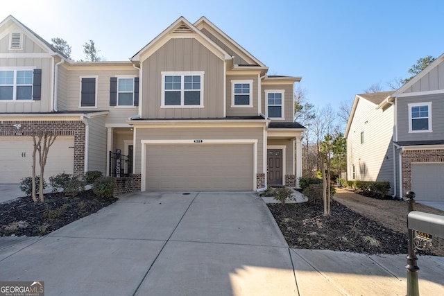 view of front facade featuring driveway, brick siding, board and batten siding, and an attached garage